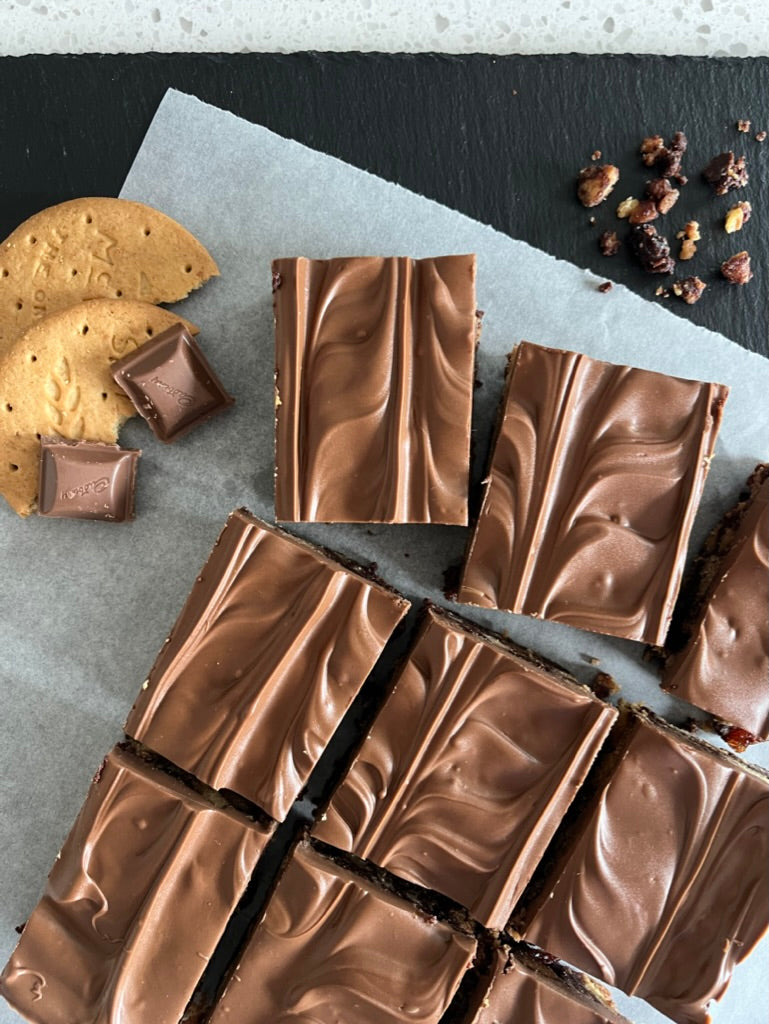 Delicious Tiffin pieces with smooth milk chocolate topping, served with digestive biscuits and chocolate chunks.