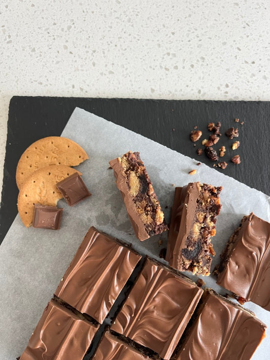 Delicious Tiffin made with digestive biscuits, raisins, cherries, and topped with milk chocolate.