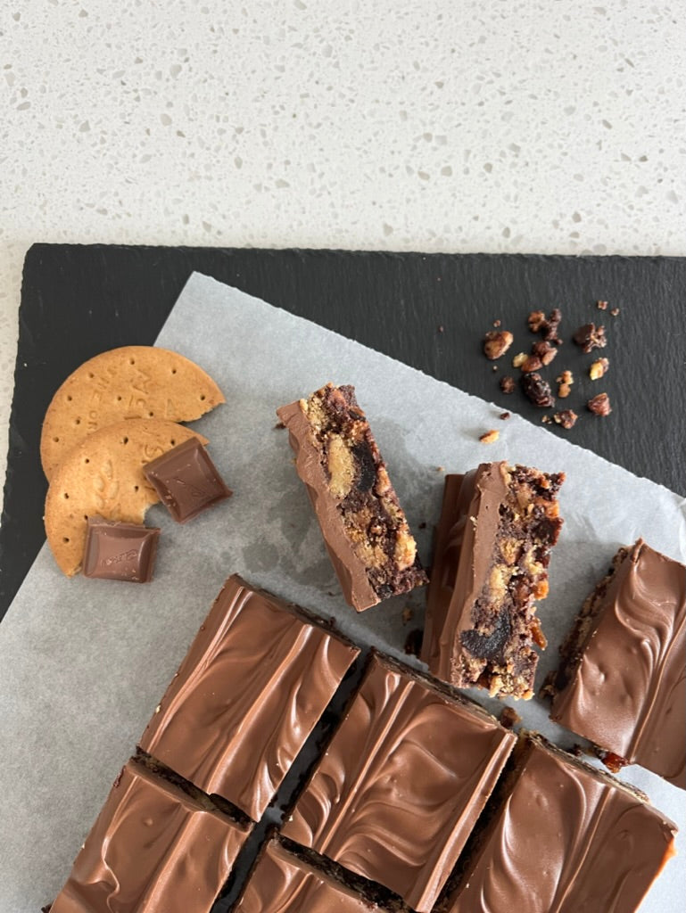 Delicious Tiffin made with digestive biscuits, raisins, cherries, and topped with milk chocolate.